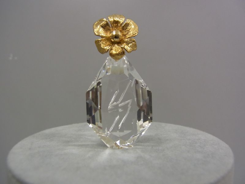 ペンダントとして使っていない時は、金の花が活けられた水晶の花瓶として飾れます。水晶にほどこされたカットは光が差し込むイメージです。